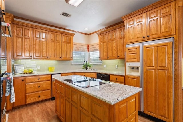 kitchen with tasteful backsplash, crown molding, light hardwood / wood-style floors, a kitchen island, and black appliances