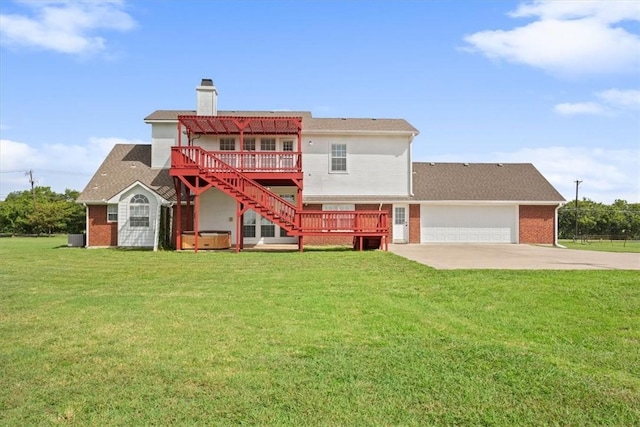 back of property with a pergola, a garage, a deck, and a lawn