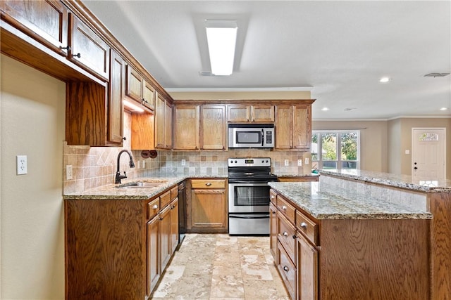 kitchen with appliances with stainless steel finishes, light stone counters, ornamental molding, and sink