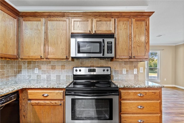 kitchen with light stone countertops, appliances with stainless steel finishes, backsplash, ornamental molding, and light hardwood / wood-style floors