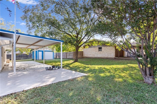 view of yard featuring an outbuilding, a garage, and a patio area