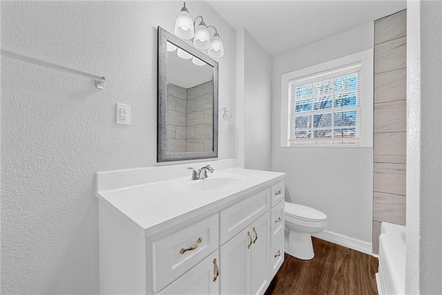 bathroom with hardwood / wood-style flooring, vanity, and toilet