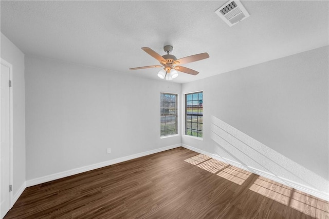 unfurnished room with a textured ceiling, dark hardwood / wood-style floors, and ceiling fan