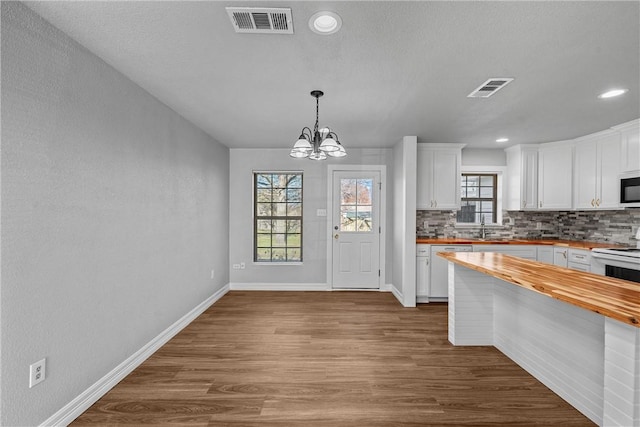 kitchen with wood counters, white appliances, and white cabinetry