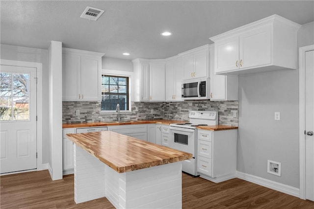 kitchen with butcher block countertops, white cabinets, a kitchen island, and white range with electric cooktop