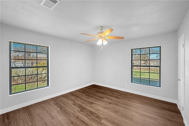 spare room featuring a textured ceiling, hardwood / wood-style flooring, plenty of natural light, and ceiling fan