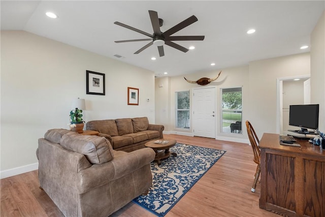 living room with light hardwood / wood-style floors, ceiling fan, and lofted ceiling