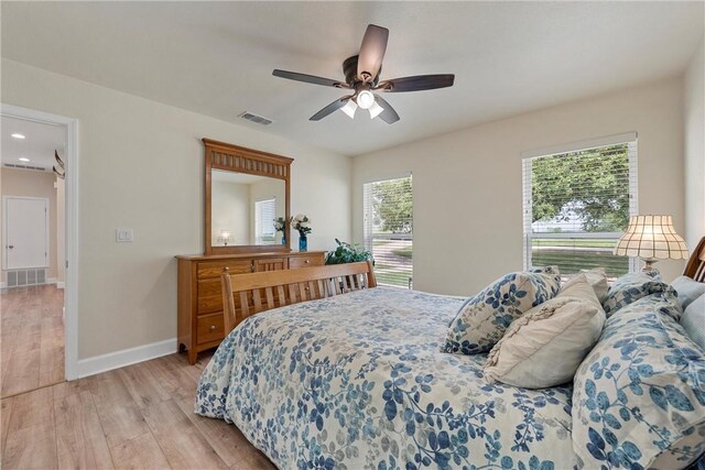 bedroom with ceiling fan, light wood-type flooring, and multiple windows