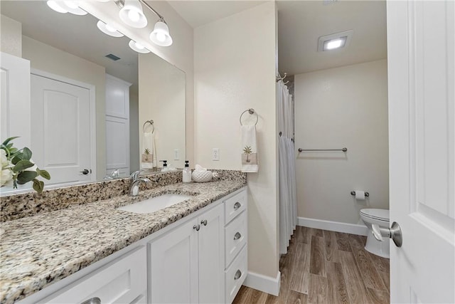 bathroom with vanity, hardwood / wood-style flooring, and toilet