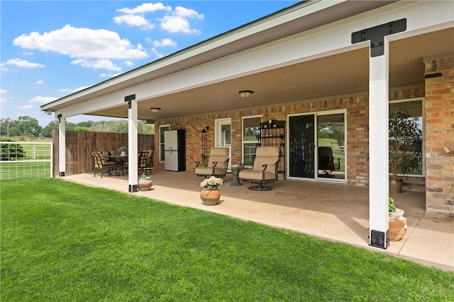 back of property with a yard and a patio