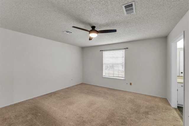 carpeted empty room featuring ceiling fan and a textured ceiling