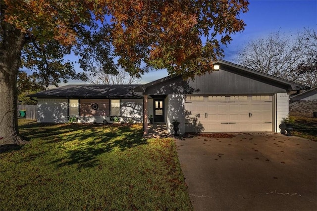 ranch-style home with a front lawn and a garage