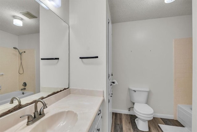 full bathroom featuring vanity, a textured ceiling, hardwood / wood-style flooring, and toilet