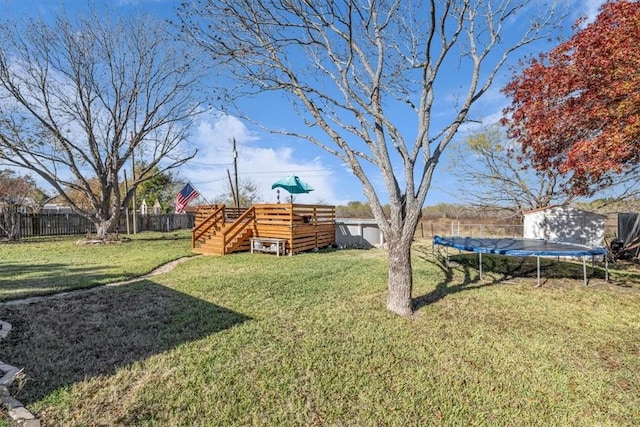 view of yard featuring a wooden deck, a shed, and a trampoline