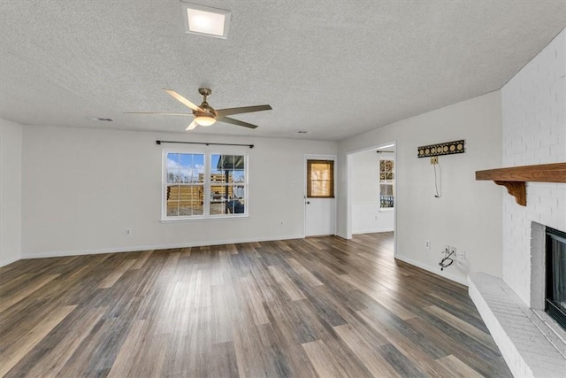 unfurnished living room with a textured ceiling, a fireplace, and dark hardwood / wood-style floors