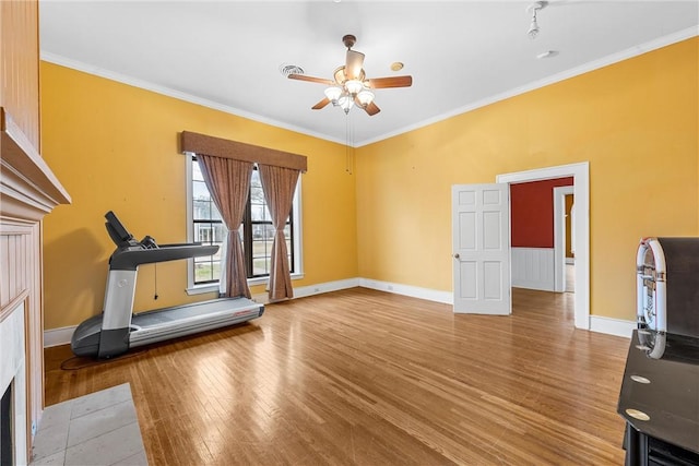 workout room with hardwood / wood-style flooring, ornamental molding, and ceiling fan