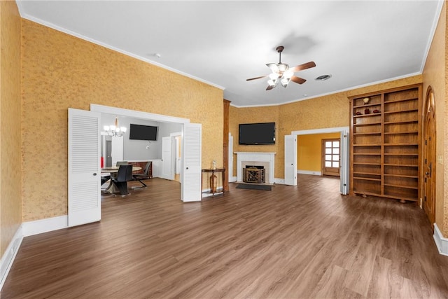 unfurnished living room featuring crown molding, wood-type flooring, and ceiling fan with notable chandelier