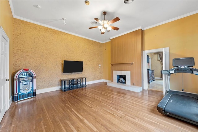 workout room with hardwood / wood-style flooring, ornamental molding, and ceiling fan