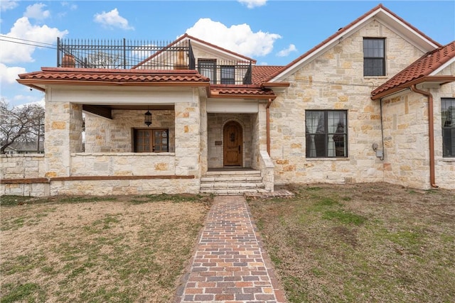 view of front of home featuring a front yard and a balcony