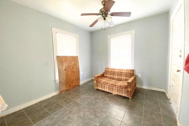 unfurnished room featuring tile patterned flooring, a ceiling fan, and baseboards