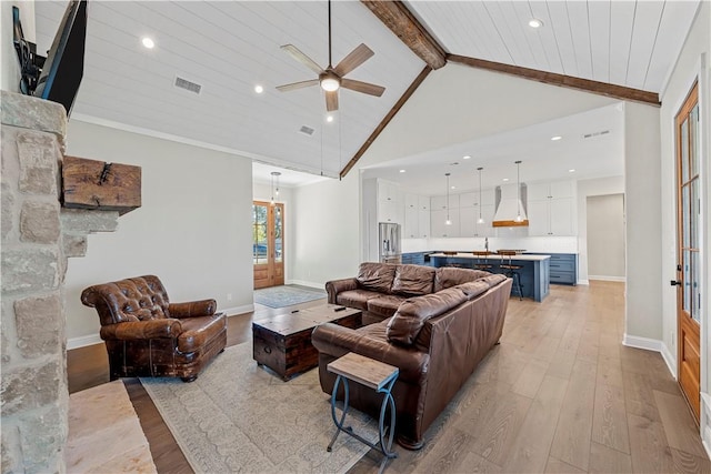 living room with beamed ceiling, light wood-type flooring, high vaulted ceiling, and ceiling fan