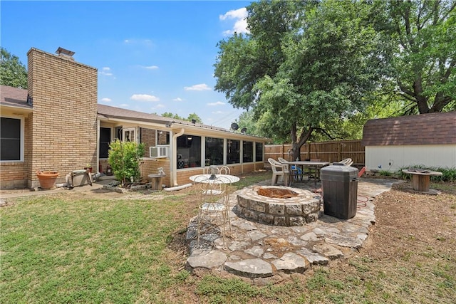 view of yard with a sunroom, cooling unit, a fire pit, and a storage shed