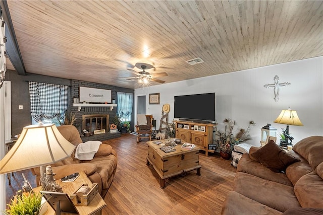 living room with hardwood / wood-style floors, ceiling fan, wooden ceiling, and a brick fireplace