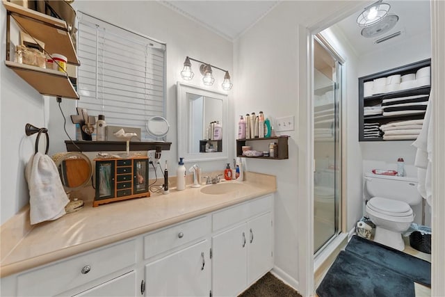 bathroom with ornamental molding, vanity, a shower with shower door, and toilet