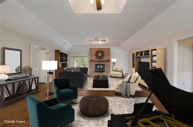 living room featuring a fireplace, hardwood / wood-style floors, vaulted ceiling, and ceiling fan