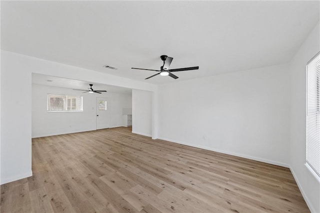 unfurnished room with a ceiling fan, light wood-style flooring, and baseboards