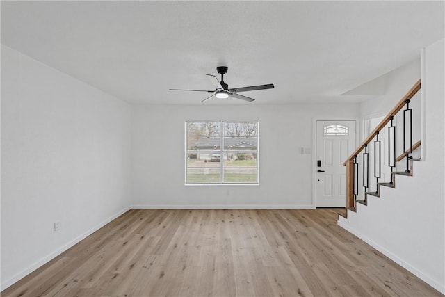 interior space with light wood-style floors, stairs, baseboards, and a ceiling fan