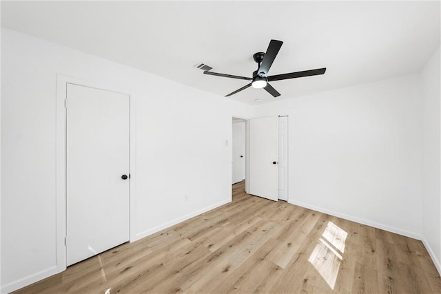 unfurnished bedroom featuring a ceiling fan, wood finished floors, visible vents, and baseboards