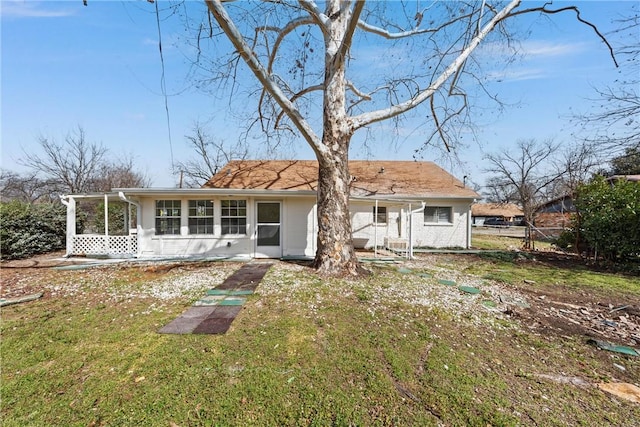 back of property featuring brick siding, a lawn, and a sunroom