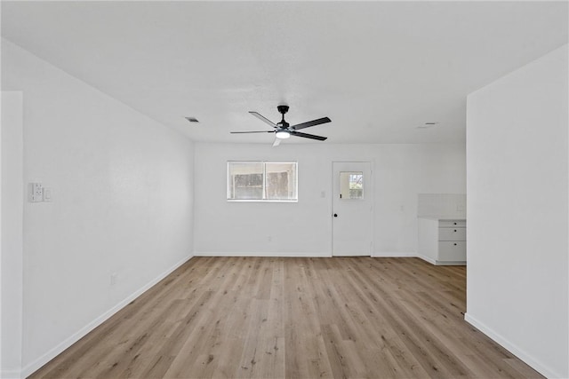 unfurnished living room with a ceiling fan, baseboards, visible vents, and light wood finished floors