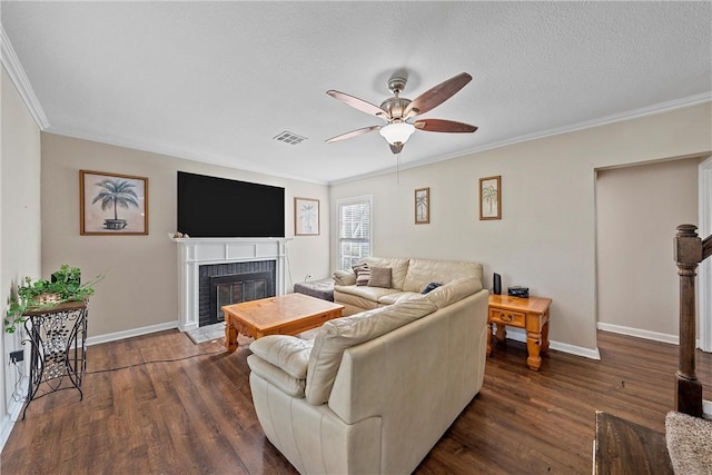 living room featuring visible vents, dark wood-style floors, a fireplace, and ornamental molding