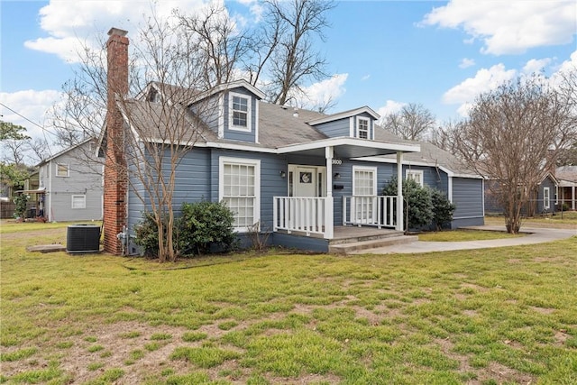 view of front of house with a front lawn and central AC