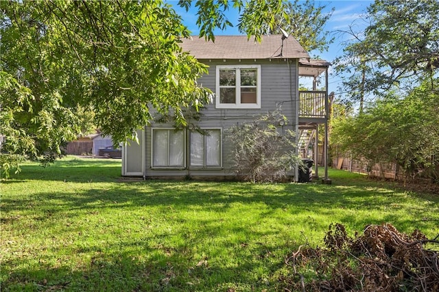 rear view of house with stairway, a yard, a wooden deck, and fence