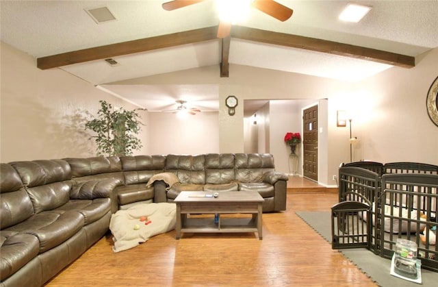 living room featuring lofted ceiling with beams, hardwood / wood-style floors, a textured ceiling, and ceiling fan