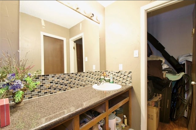 bathroom featuring vanity and backsplash