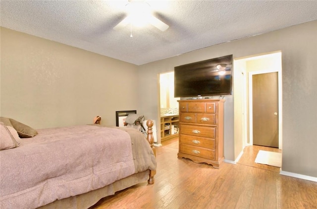 bedroom with ceiling fan, light hardwood / wood-style flooring, and a textured ceiling