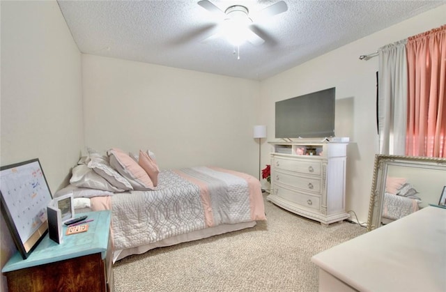 carpeted bedroom featuring ceiling fan and a textured ceiling