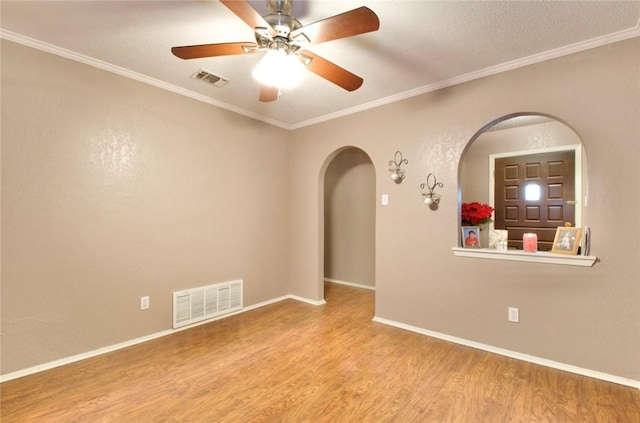 spare room with hardwood / wood-style flooring, crown molding, and ceiling fan