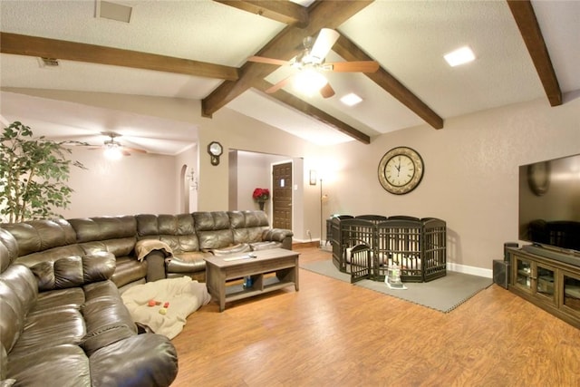 living room featuring a textured ceiling, light hardwood / wood-style flooring, lofted ceiling with beams, and ceiling fan