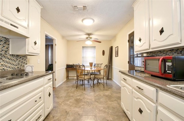 kitchen featuring tasteful backsplash, ceiling fan, a textured ceiling, and white cabinets