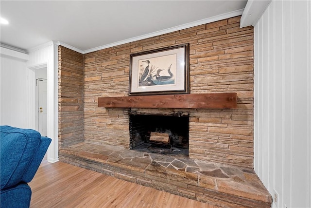 interior details featuring a fireplace, wood-type flooring, and crown molding