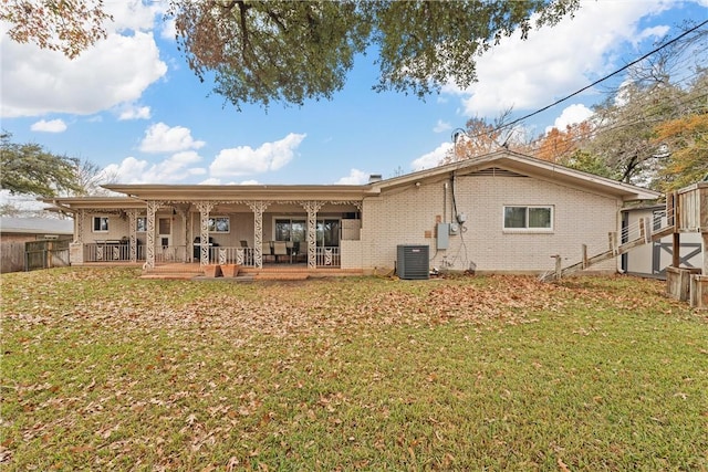 rear view of house featuring a lawn, central air condition unit, and a wooden deck