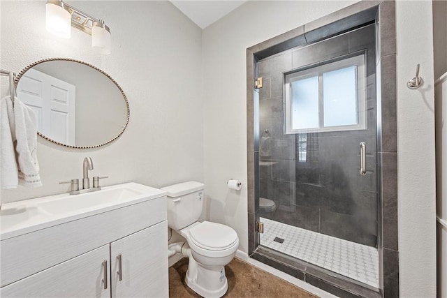 bathroom featuring vanity, toilet, and a shower with shower door