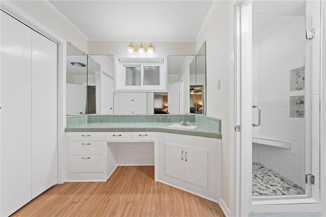 bathroom with decorative backsplash, a shower with door, vanity, and hardwood / wood-style flooring