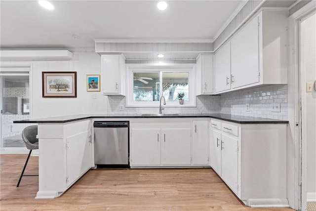 kitchen featuring white cabinets, crown molding, sink, light hardwood / wood-style flooring, and stainless steel dishwasher