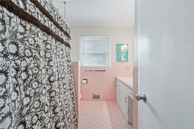 bathroom featuring vanity, tile patterned floors, and tile walls